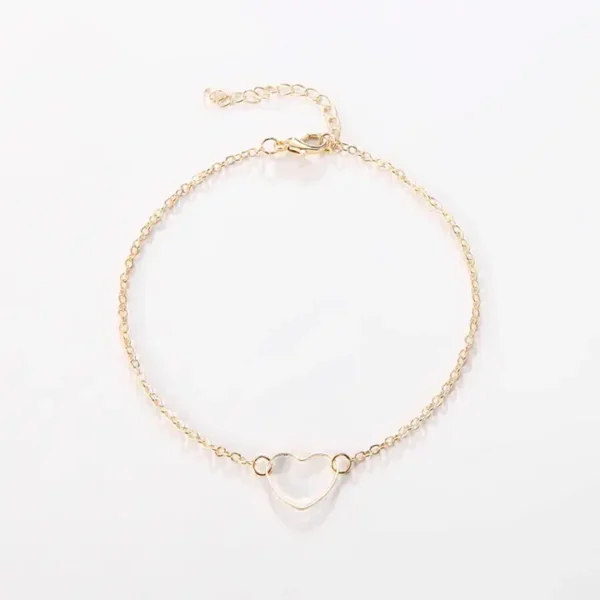 A gold chain with a heart shaped stone on it.